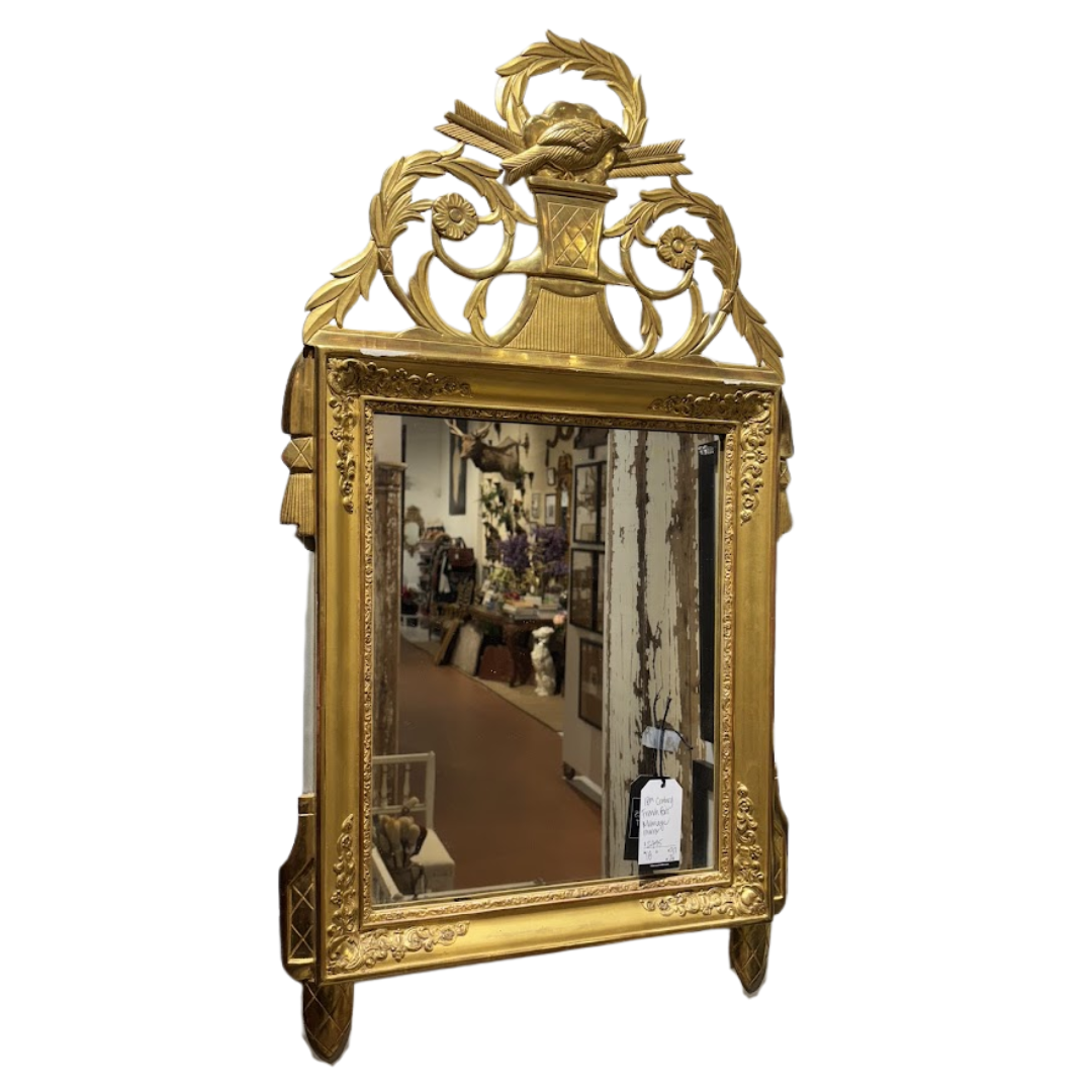 Decorative gold-framed mirror with intricate designs on a white background