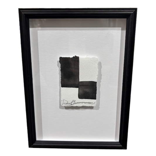 Framed artwork with black and white abstract design on a white background