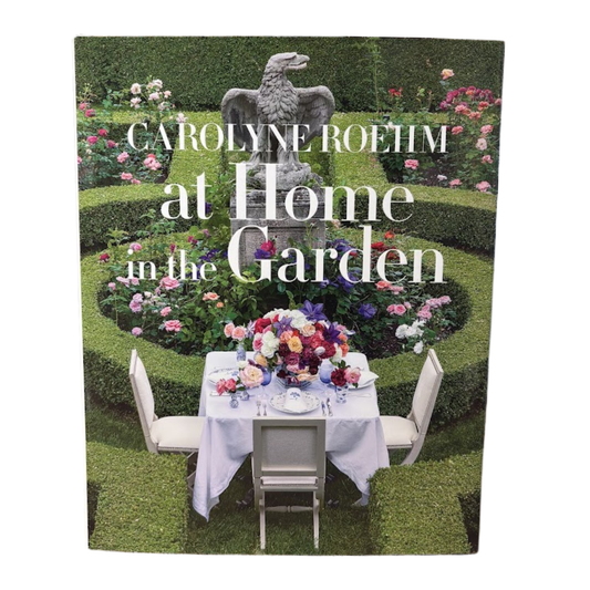 Book cover of 'Carolyne Roehm at Home in the Garden' with a garden scene and table setting.