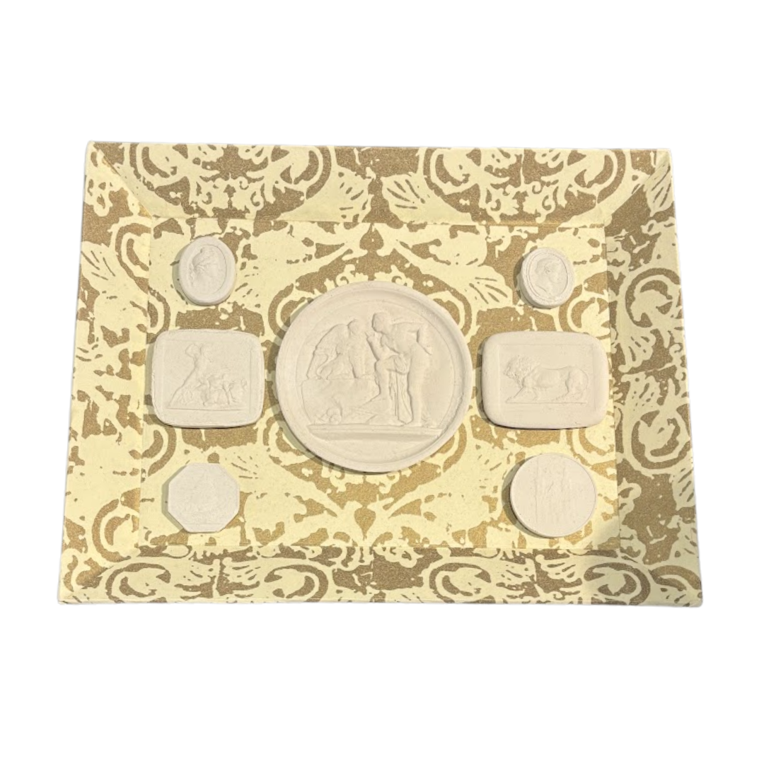 Set of six stone seals on a decorative card with intricate patterns
