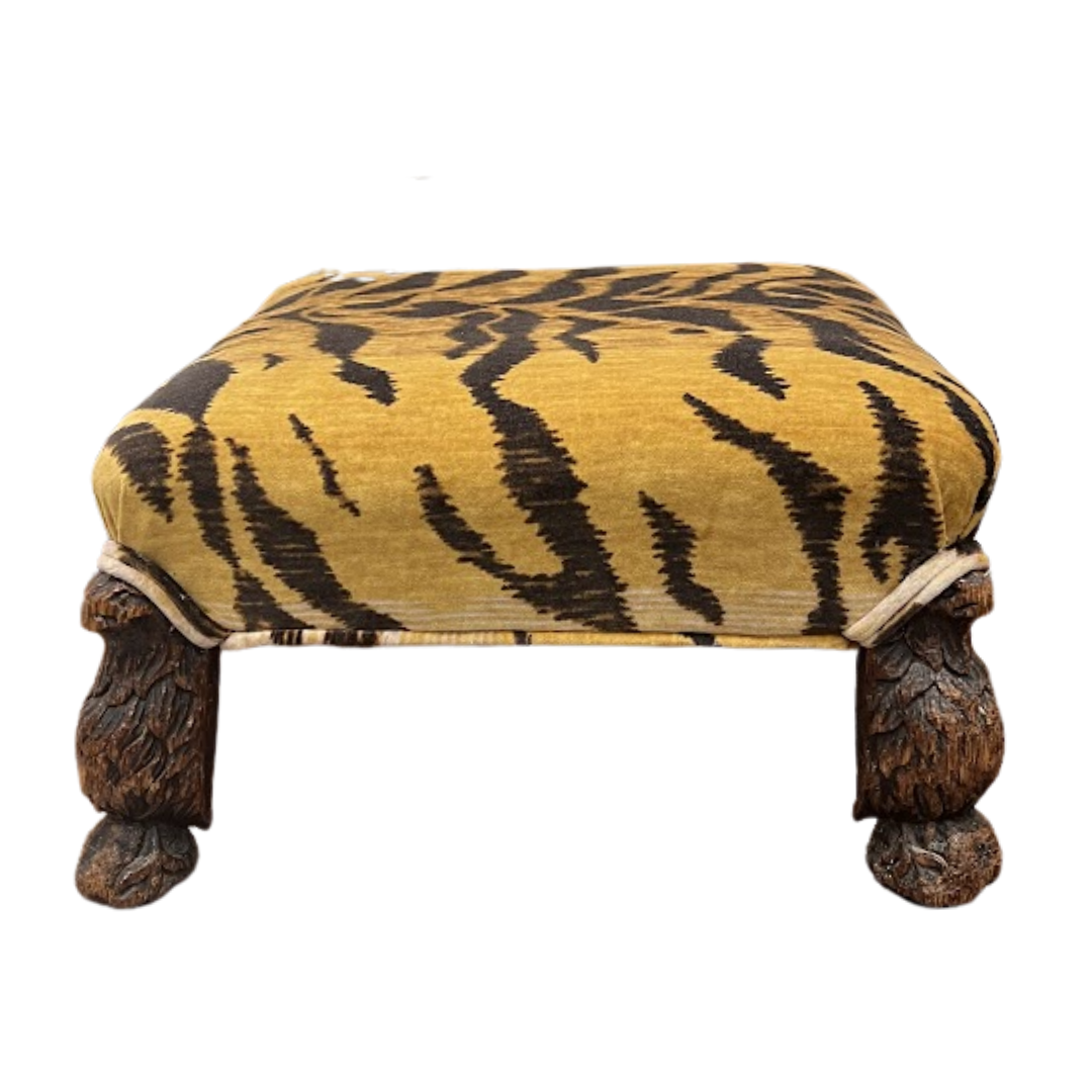 Footstool with tiger stripe pattern and wooden legs on a white background