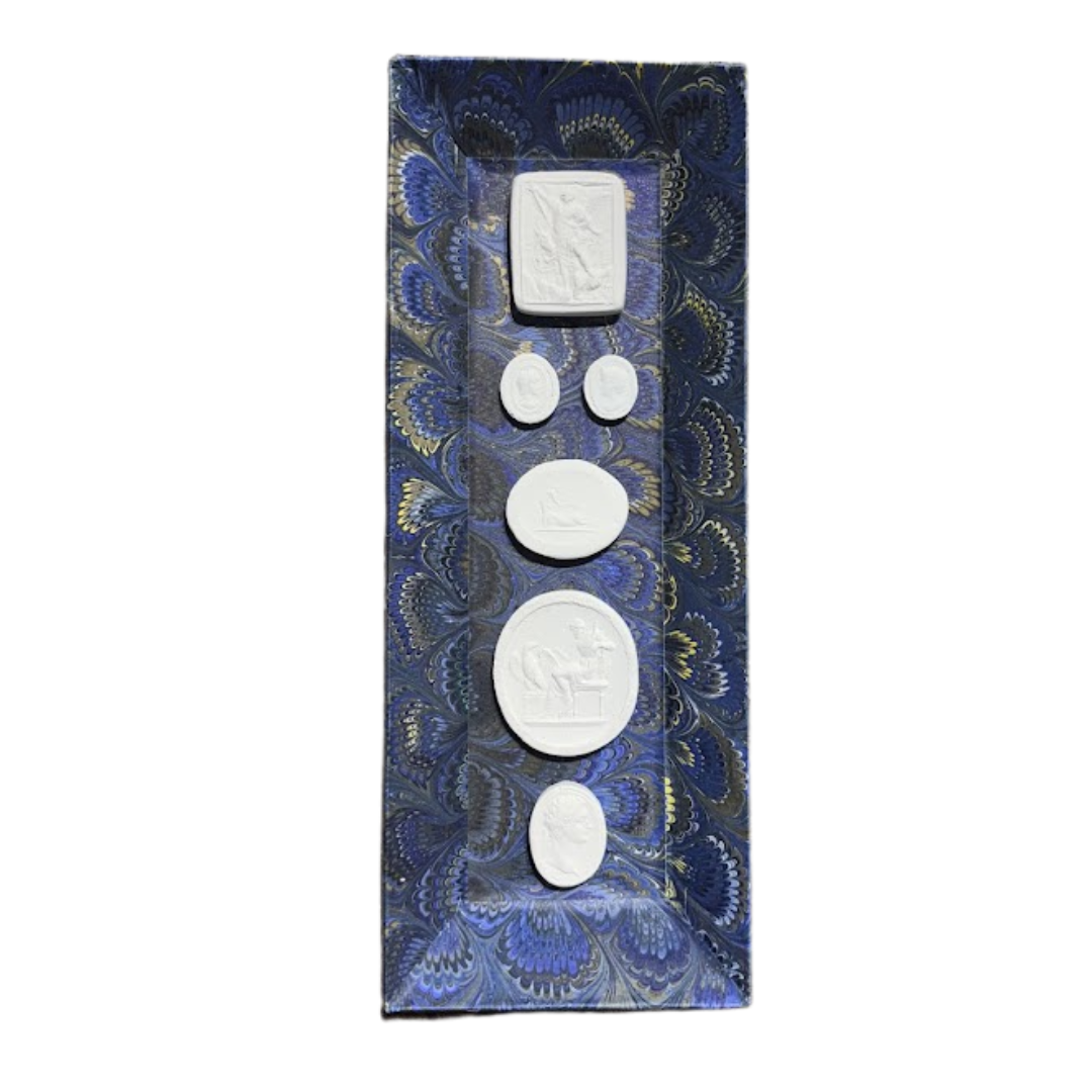 Set of white intaglios on a blue patterned tray