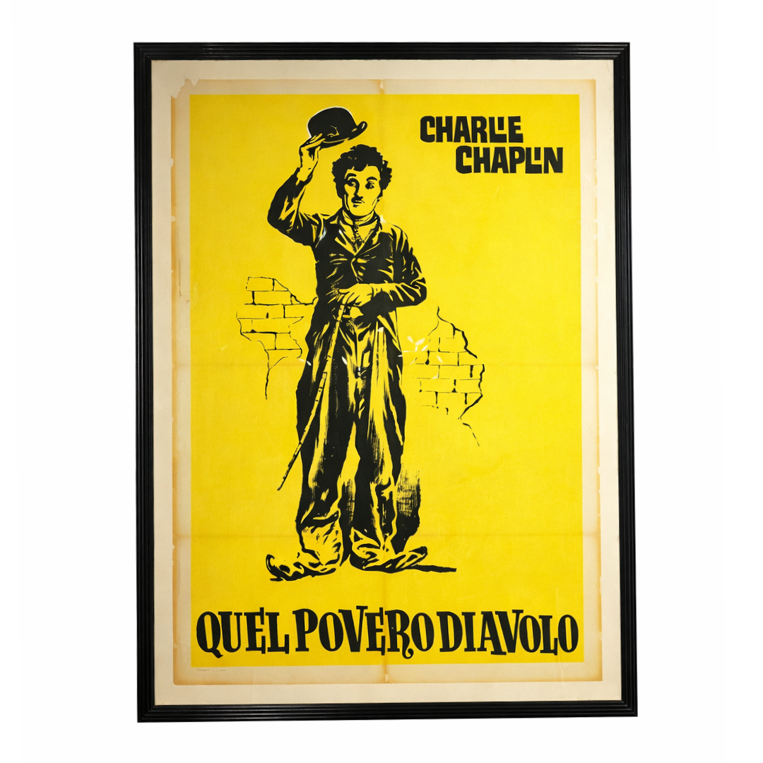 Framed poster of Charlie Chaplin with a yellow background and black text.