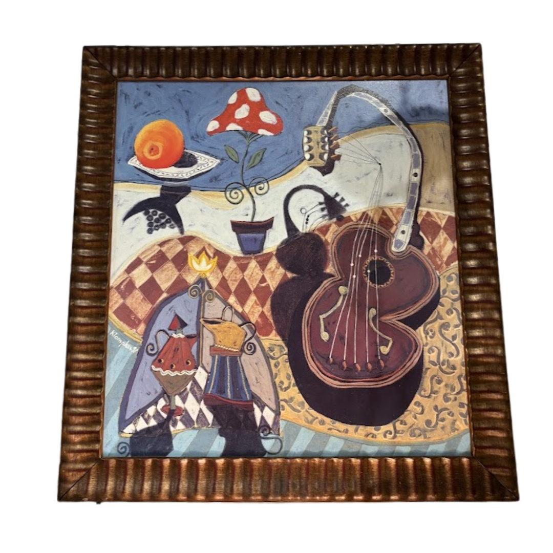 Framed artwork with a colorful depiction of a violin, mushroom, and other elements on a checkered tablecloth.