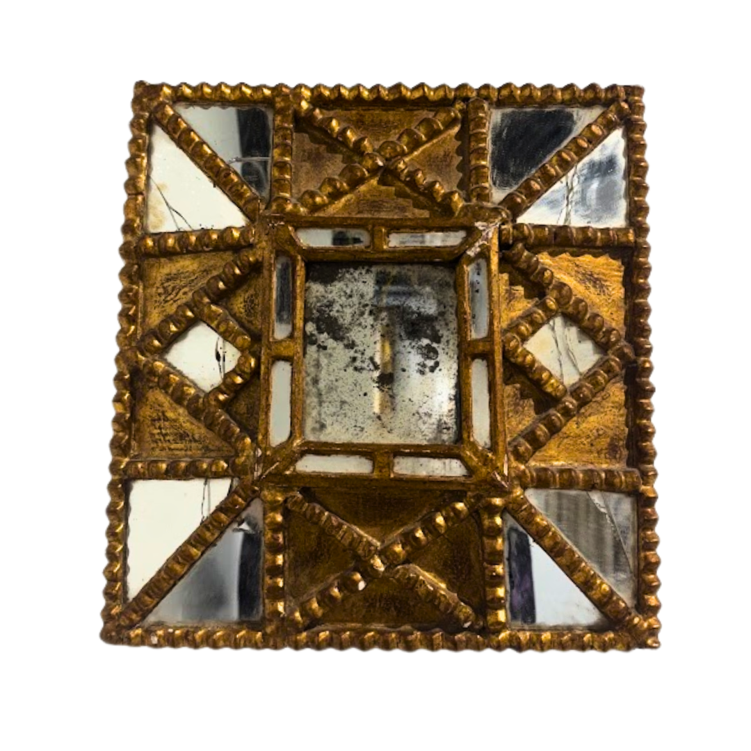 Decorative square mirror with gold frame and reflective surface on a white background