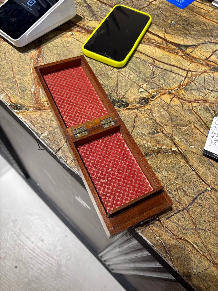 Wooden stamp box with red patterned paper on a marble surface