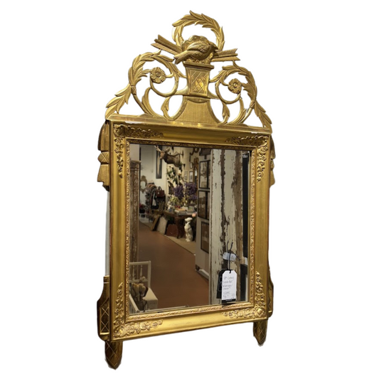 Decorative gold-framed mirror with intricate designs on a white background