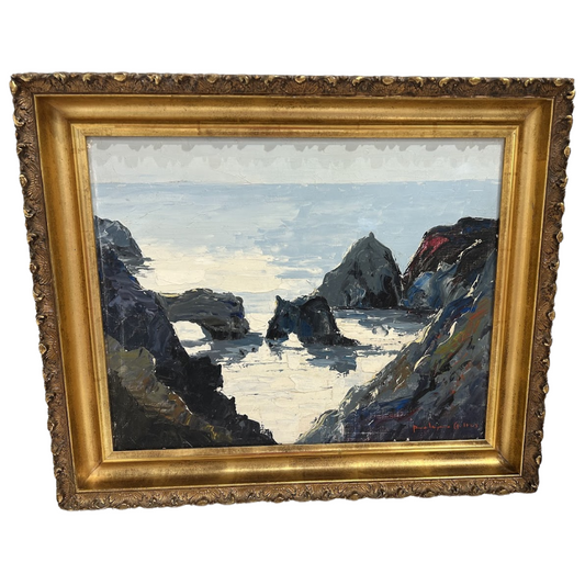 Painting of a coastal scene with rocks and water in a gold frame.