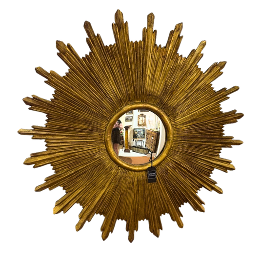 Gold sunburst mirror with a tag on a white background