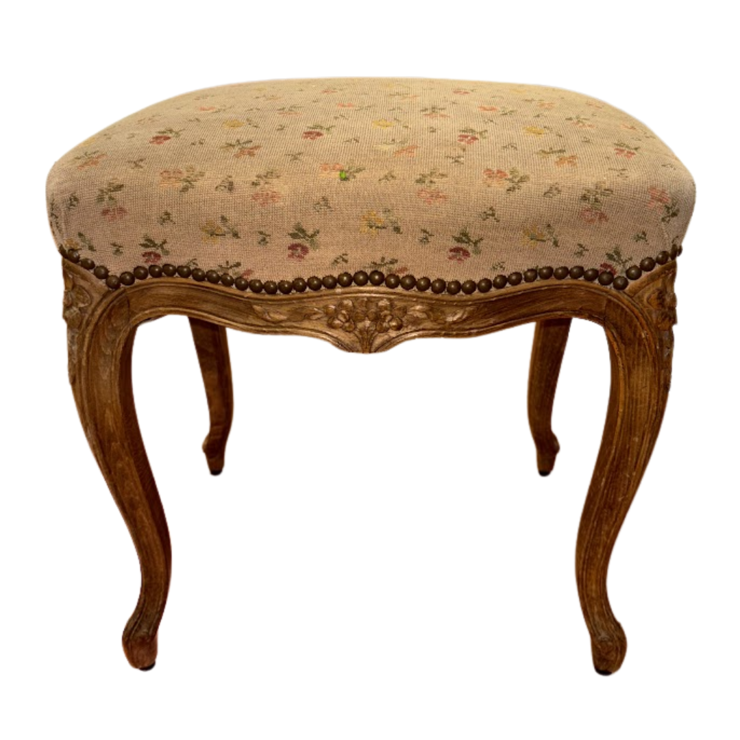 Decorative stool with floral patterned cushion and wooden legs on a white background