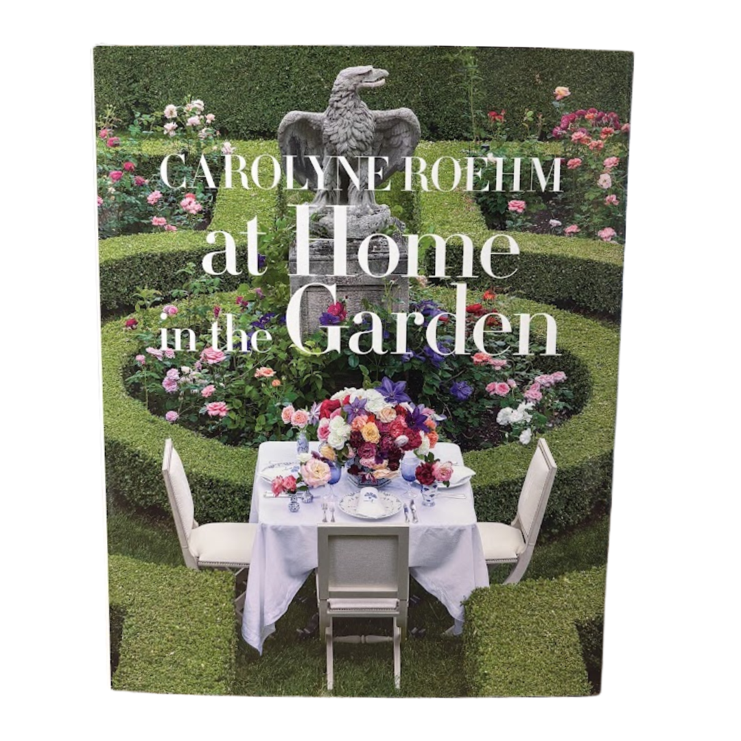 Book cover of 'Carolyne Roehm at Home in the Garden' with a garden scene and table setting.