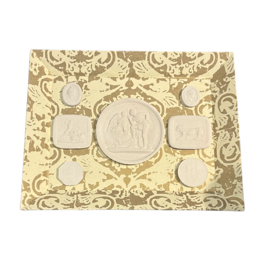 Set of six stone seals on a decorative card with intricate patterns