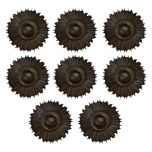 Set of eight bronze sunburst wall decor pieces on a white background