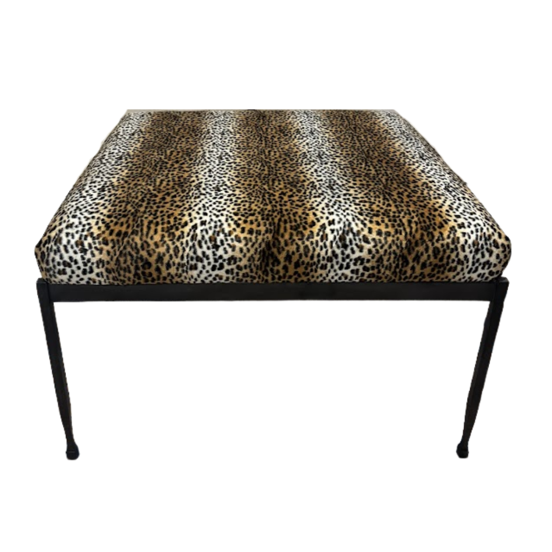 Leopard print ottoman with black legs on a white background