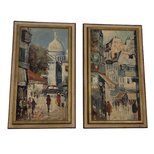 Two framed paintings of urban scenes with people and architectural elements.