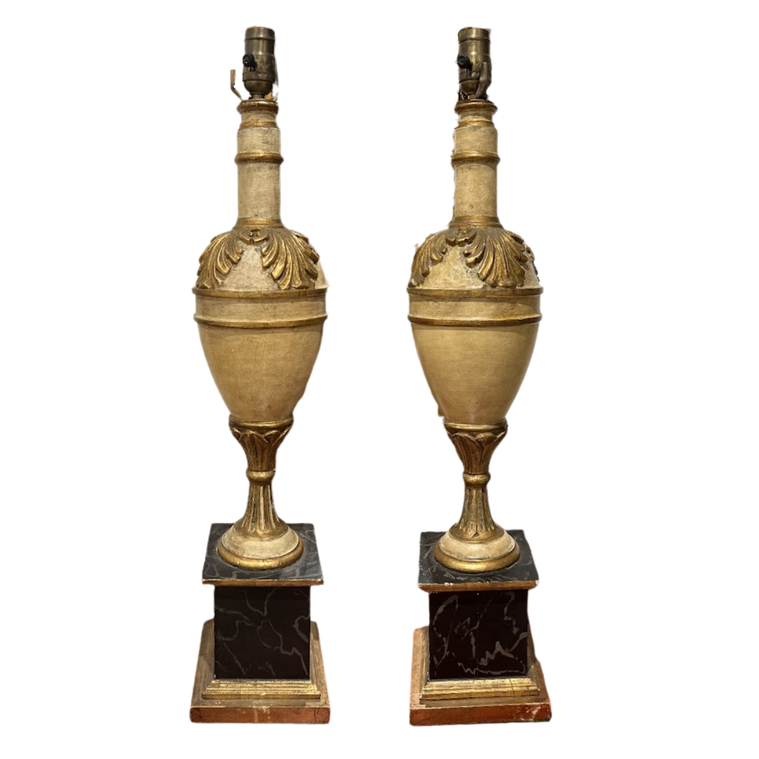 Pair of ornate gold lamps with marble bases on a white background
