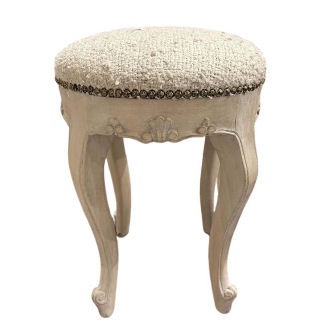 Decorative stool with a textured cushioned top on a white background