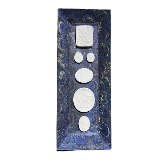 Set of white intaglios on a blue patterned tray