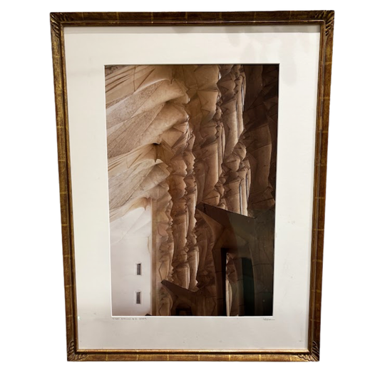 Framed photograph of a textured wall with a wooden frame on a white background