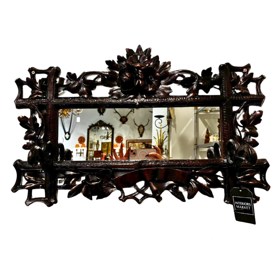 Decorative mirror with intricate carvings on a white background