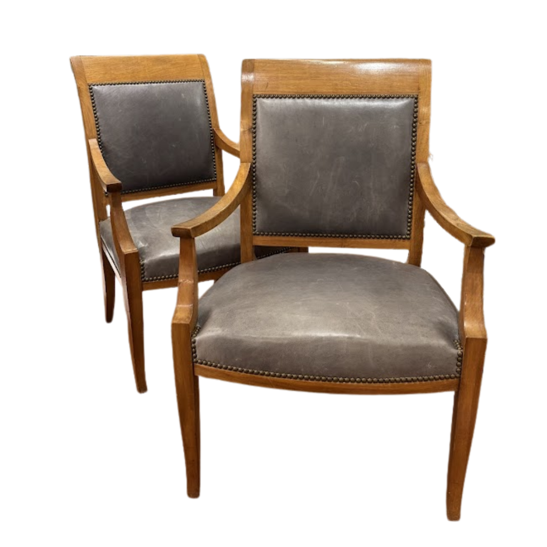 Two wooden armchairs with gray leather seats on a white background