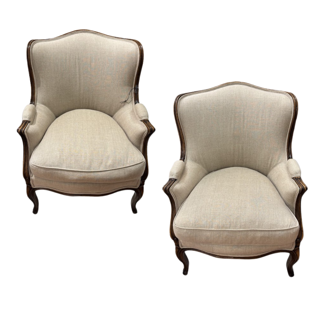 Pair of beige upholstered armchairs with wooden frames on a white background
