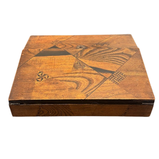 Wooden box with geometric carvings on a white background