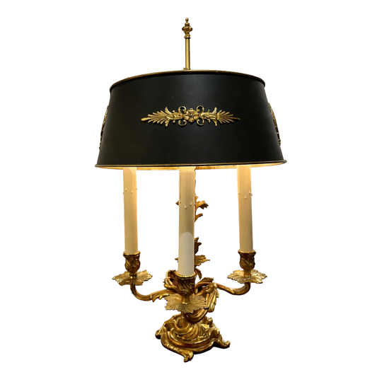 Decorative table lamp with black shade and gold base on a white background
