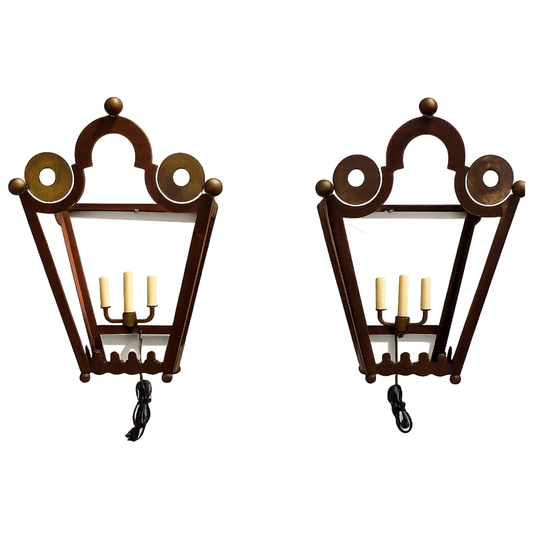 Pair of decorative wall sconces with tole frames and candle-like lights on a white background.