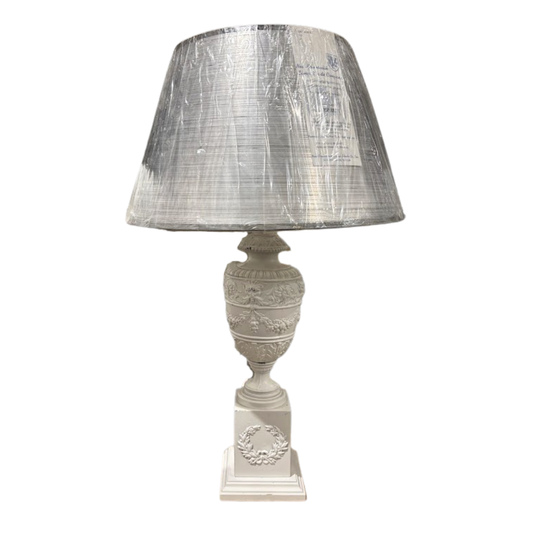 Decorative table lamp with a textured silver shade on a white background