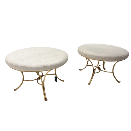 Two round ottomans with gold metal bases on a white background