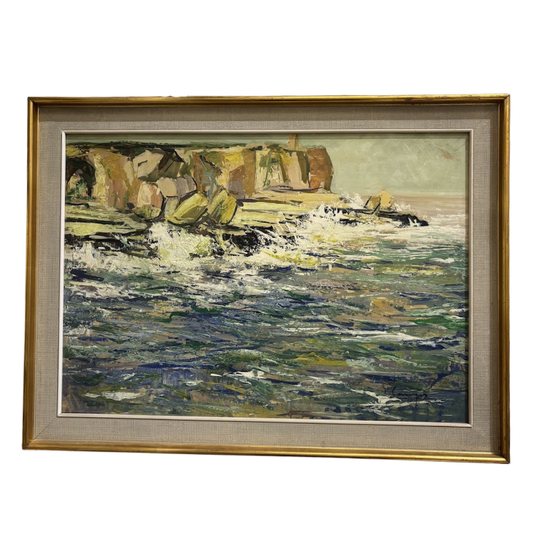 Framed painting of a coastal scene with waves and cliffs.