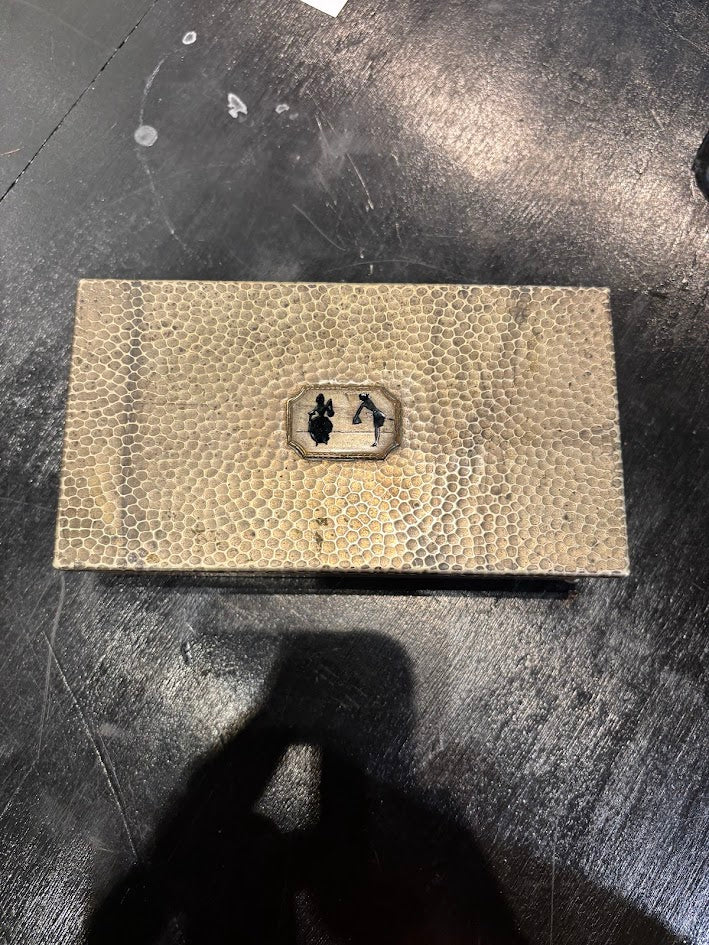Textured rectangular object with a logo on a dark surface