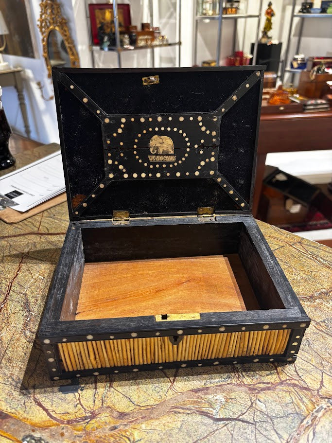 Decorative wooden box with intricate designs on a patterned surface