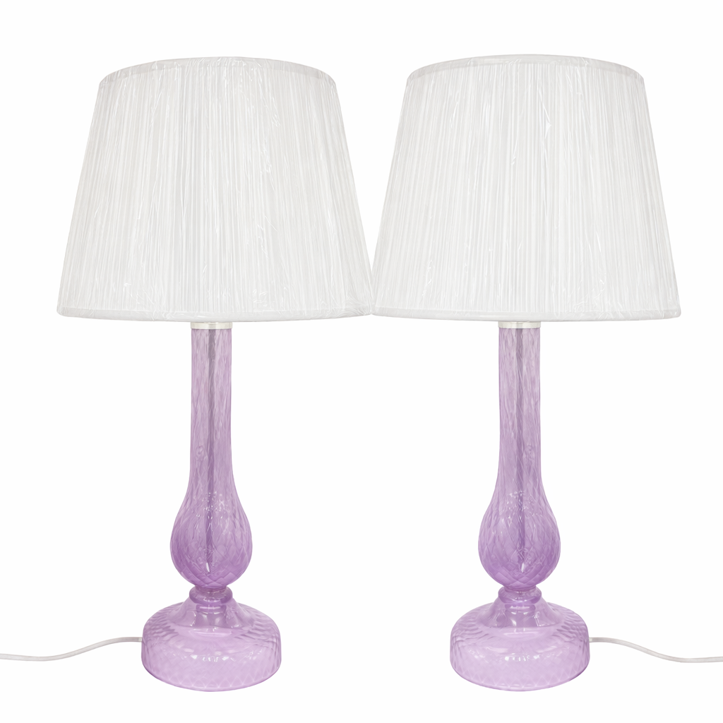 Two purple table lamps with white lampshades on a white background