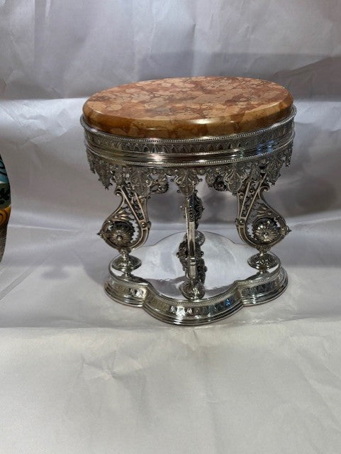 Decorative stool with marble top and silver base on a white background