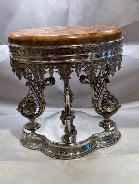 Decorative table with silver base and wooden top on a white background